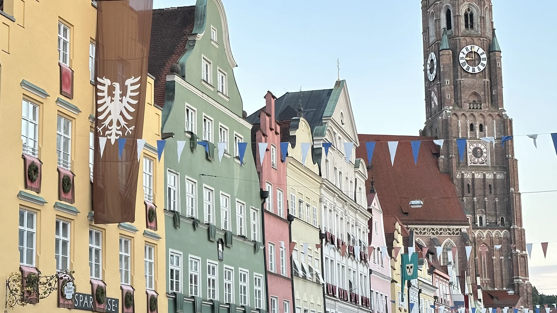 Cubea | Urlaub³ im Bayerischen Wald Bunte historische Gebäude und Kirchturm mit vielen Menschen auf belebtem Platz