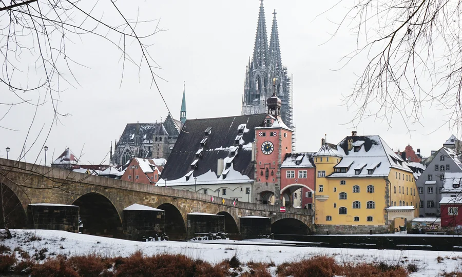 Verschneite Altstadt mit Brücke und Dom im Hintergrund im Winter
