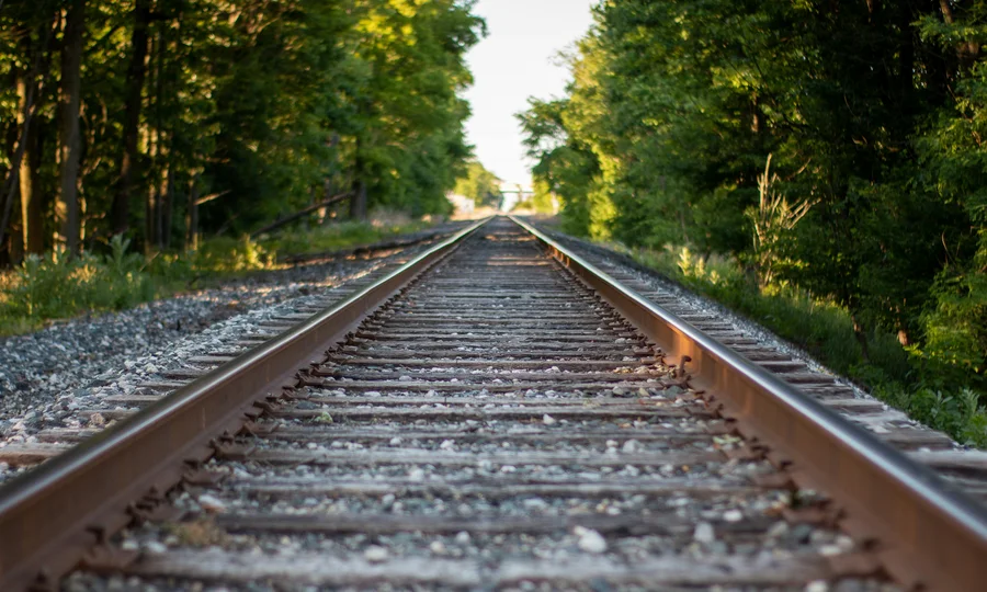 Cubea | Anreise und häufig gestellte Fragen Blick auf Eisenbahnschienen, umgeben von grünen Bäumen bei Sonnenlicht