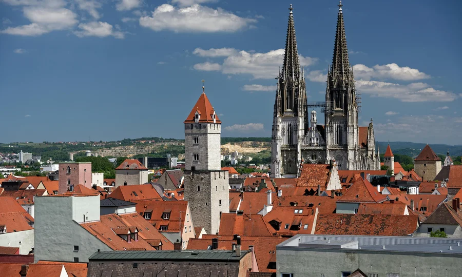 Blick auf Regensburg mit Dom St. Peter und roten Dächern bei blauem Himmel