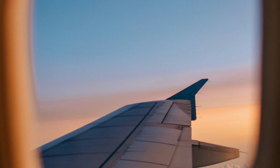 Cubea | Anreise und häufig gestellte Fragen Blick aus dem Flugzeugfenster auf Tragfläche bei Sonnenuntergang