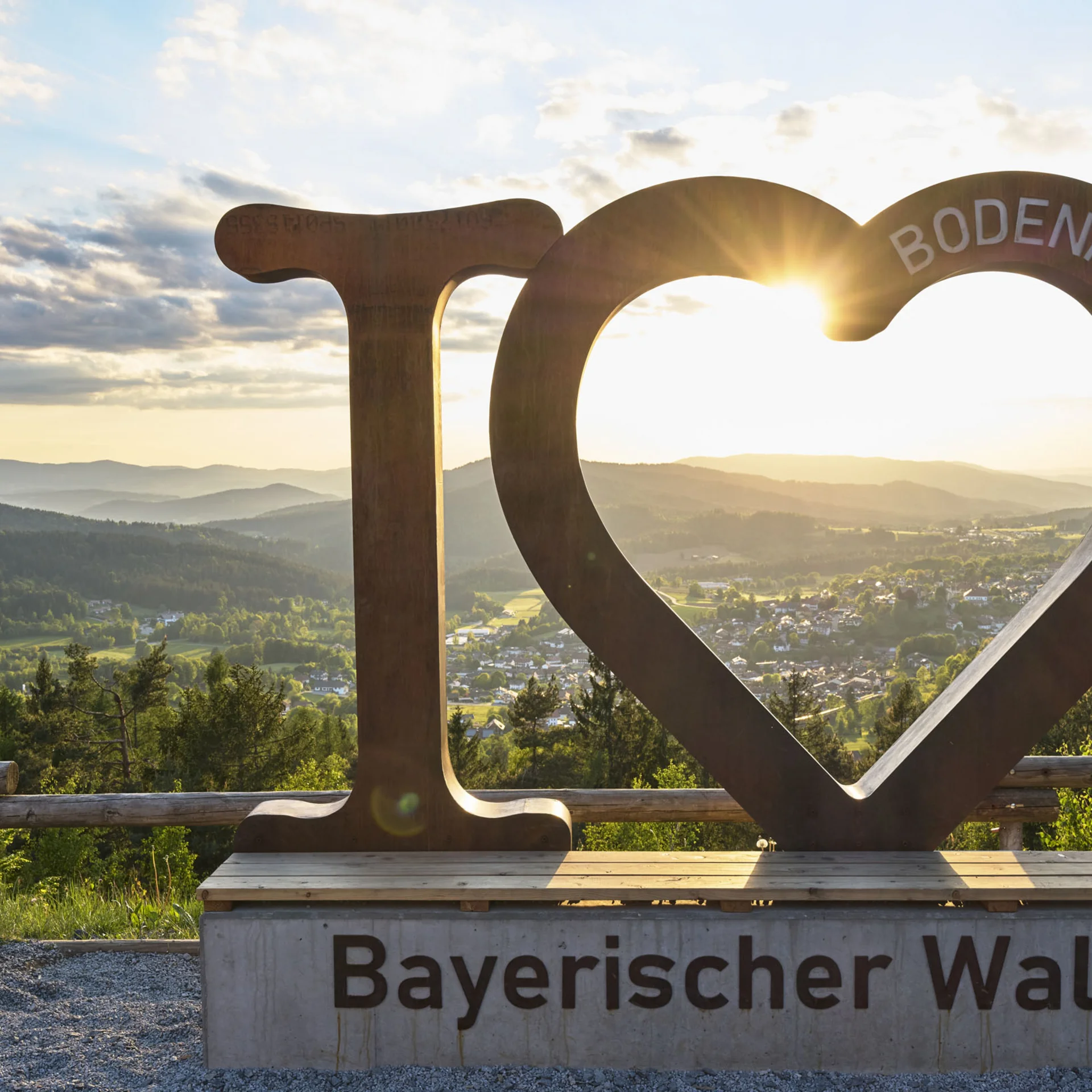 I love Bayerischer Wald Skulptur mit Sonnenuntergang und Berglandschaft