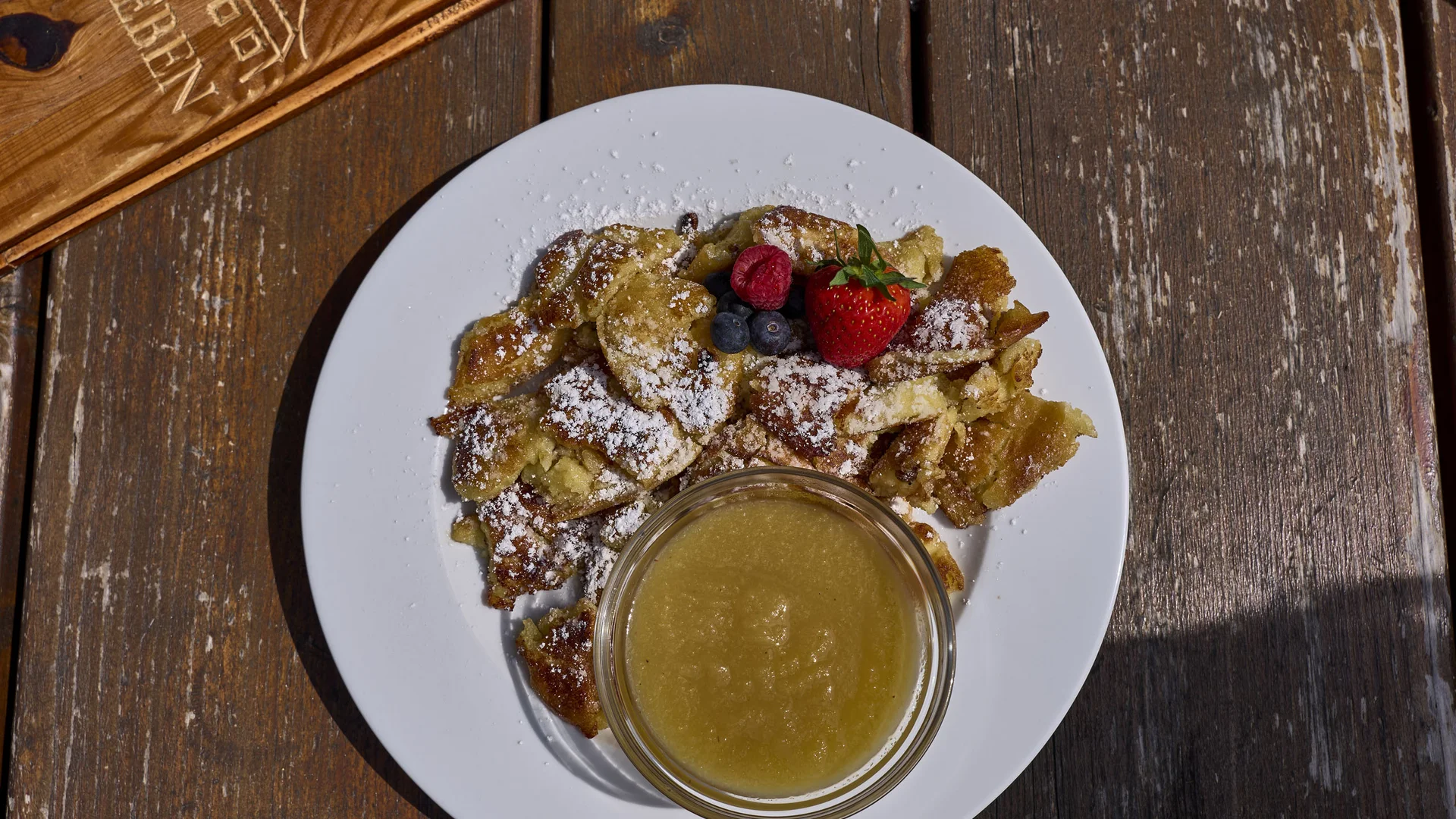 Cubea | Kuratierte Empfehlungen für Restaurants in Bodenmais Kaiserschmarrn mit Puderzucker, Beeren und Apfelmus auf weißem Teller