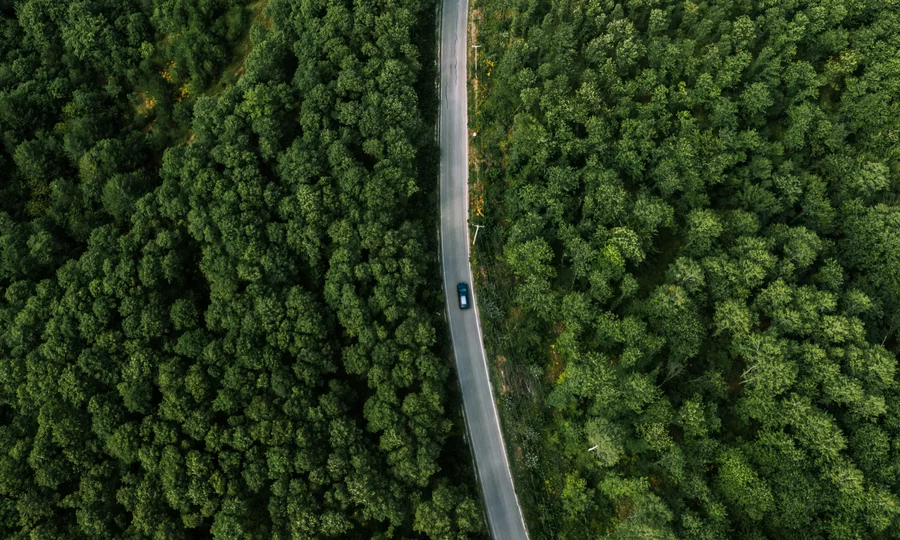 Cubea | Anreise und häufig gestellte Fragen Luftaufnahme einer Straße durch dichten grünen Wald mit einem Auto