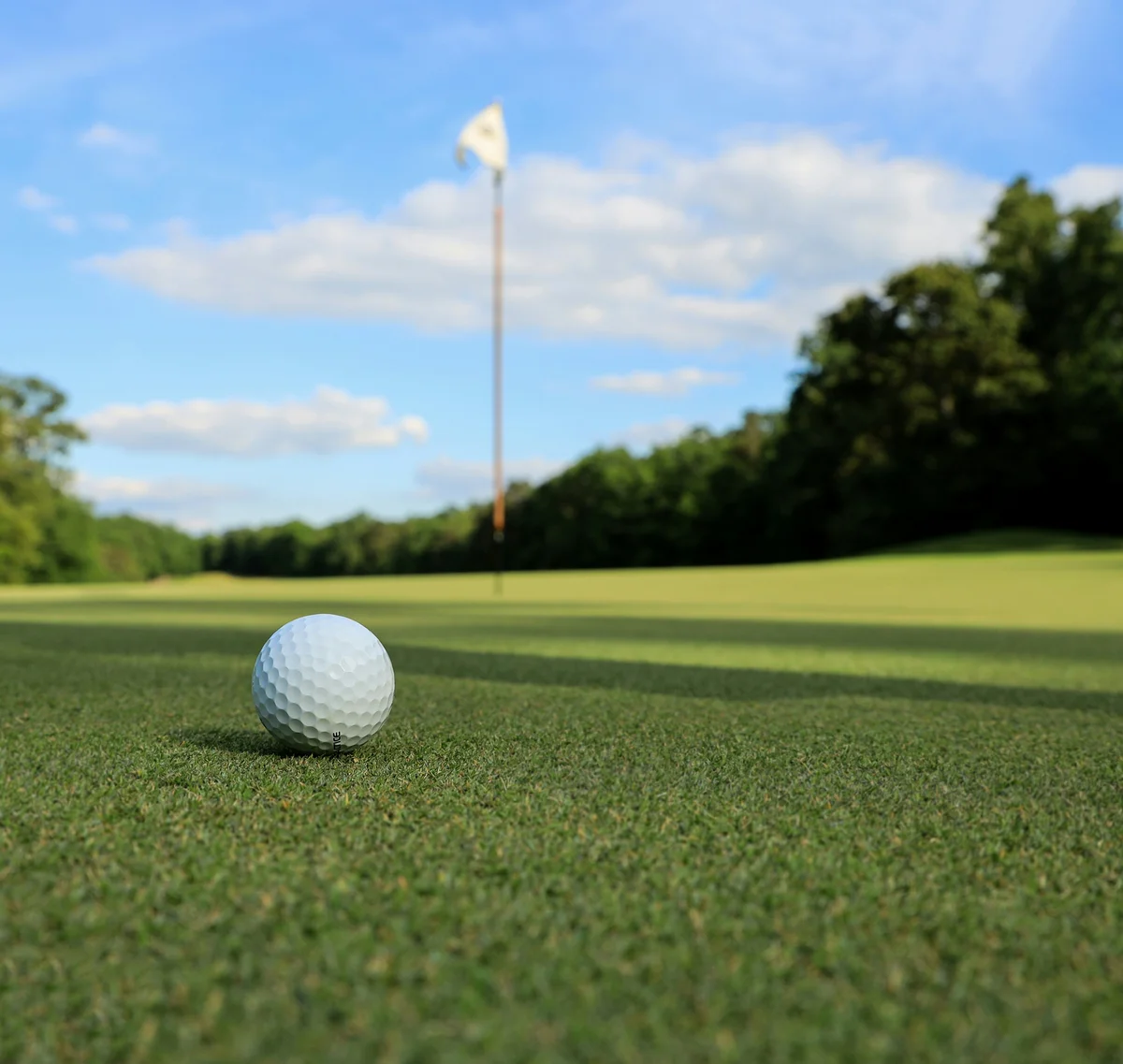 Cubea | Aktivurlaub in Bodenmais, der potenziert Golfball auf dem Grün nahe Fahne bei sonnigem Himmel