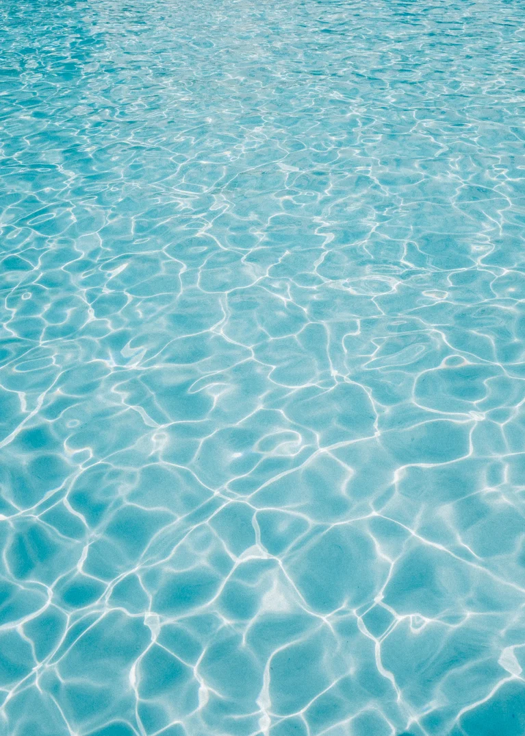 Klares, blaues Wasser mit Sonnenreflexionen auf der Oberfläche